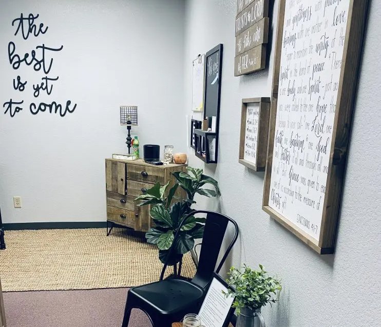 Office console table with word the best is yet to come on the wall